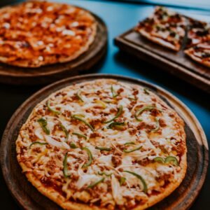 A mouthwatering display of freshly baked pizzas with various toppings on wooden trays.