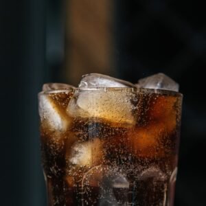 Cooling beverage with fizzy bubbles and ice cubes in a clear glass.